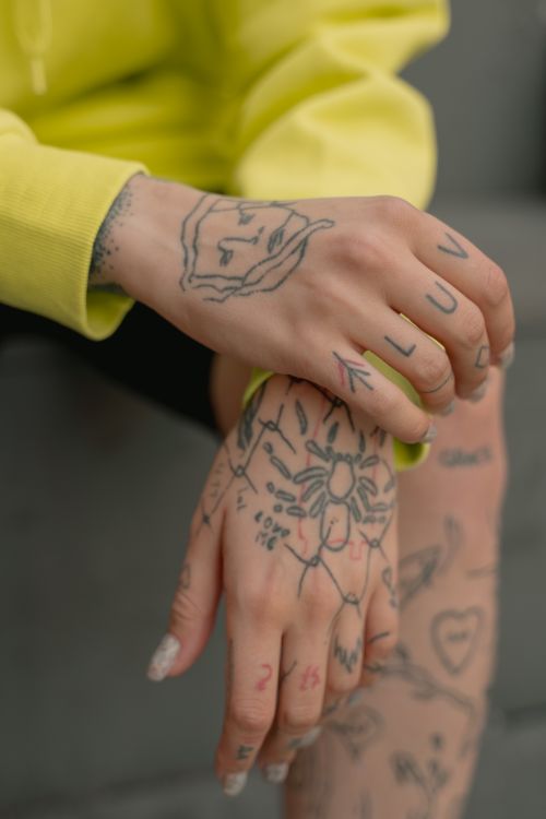 Free Detailed shot of hands with tattoos, featuring artistic designs and hand-lettering. Stock Photo