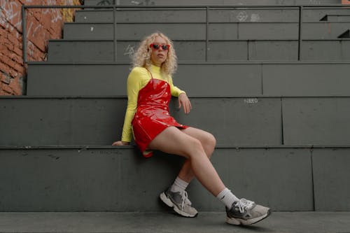 Woman Wearing Red Leather Dress Sitting on Stairs 