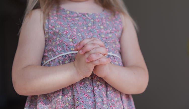 Cute Unrecognizable Girl With Prayer Hands On Gray Background