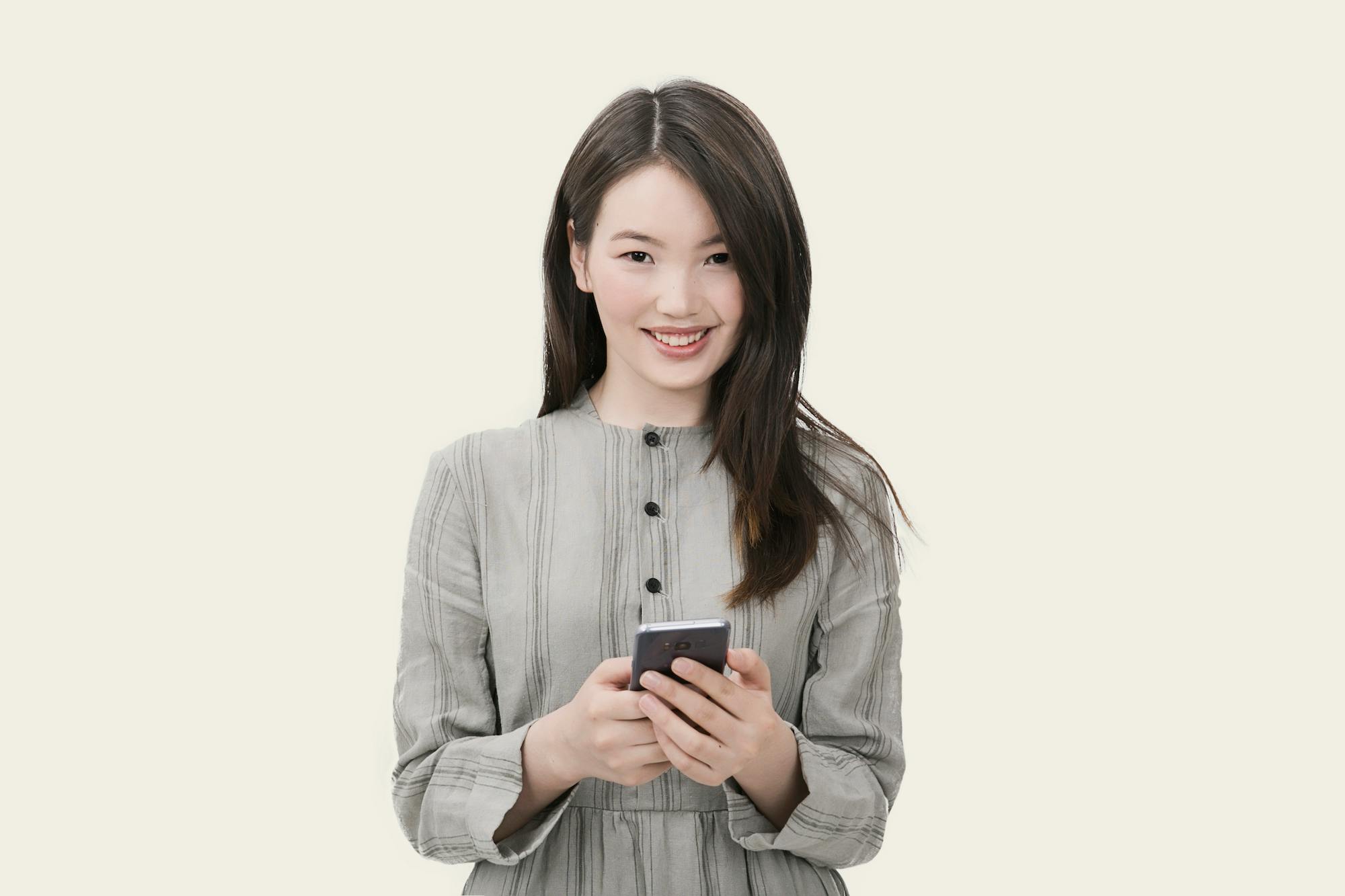 woman in gray button up long sleeved dress holding black smartphone