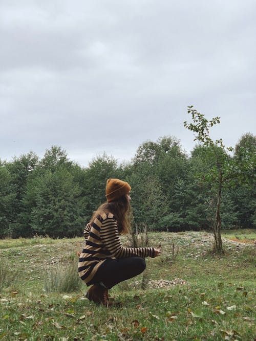 Woman sitting on ground leaning on tree · Free Stock Photo