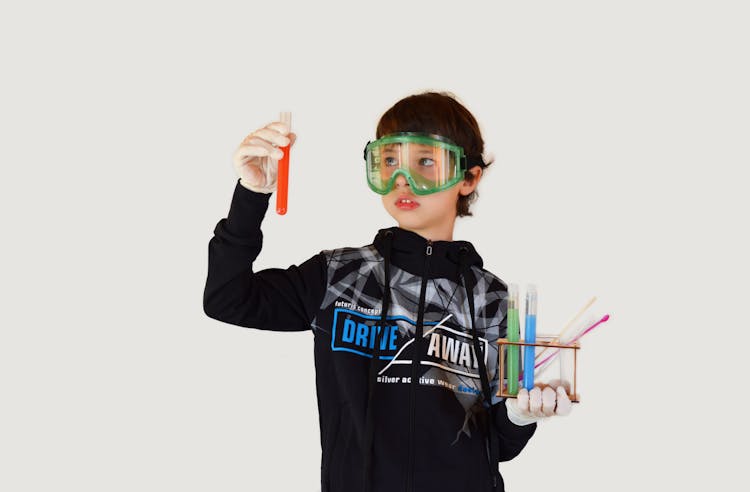 Boy With Assorted Test Tubes On Light Background