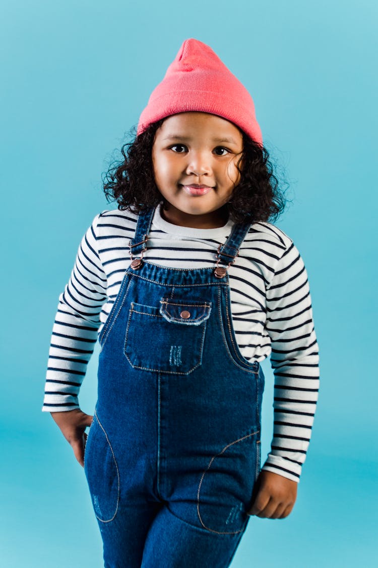 African American Girl In Denim Overall And Knitted Hat