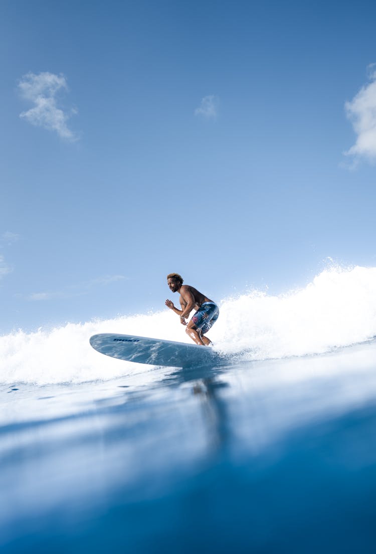 Man Surfing On Blue Sea Water