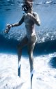 Faceless woman in snorkeling mask swimming in seawater