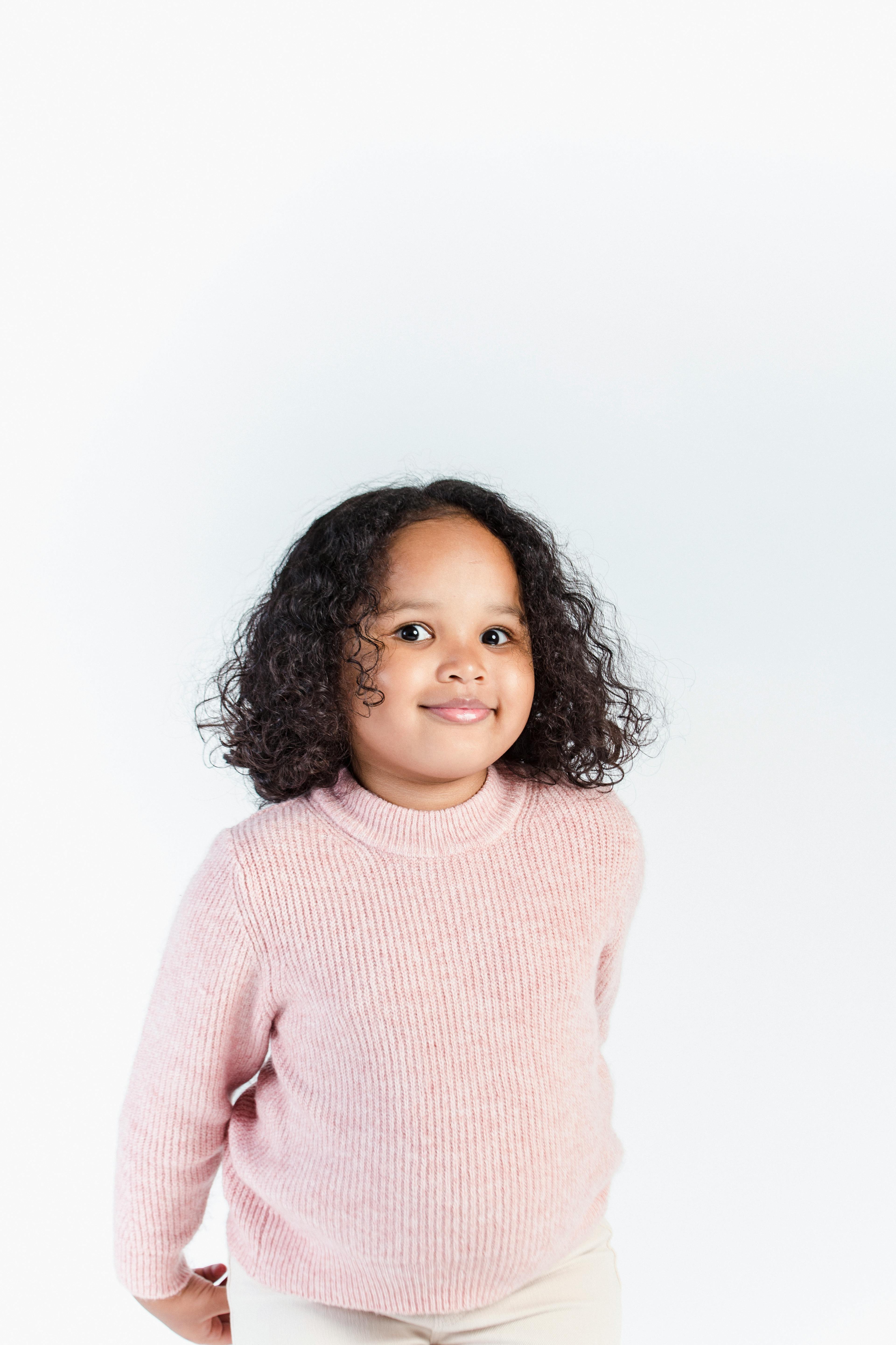 content black girl in cozy sweater against white wall