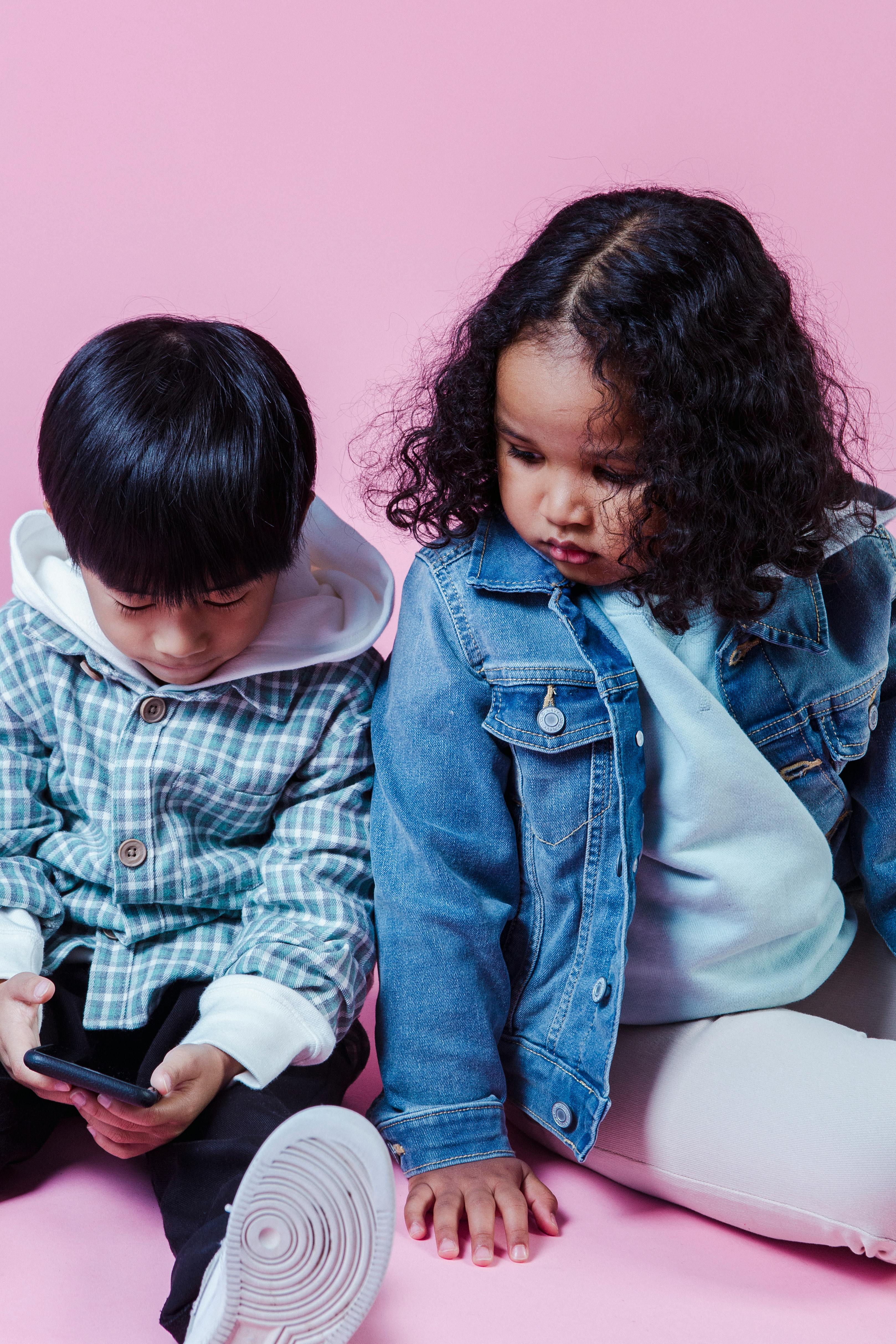 focused diverse kids browsing smartphone on floor