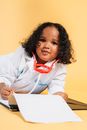 Cute black child imitating doctor while playing in studio