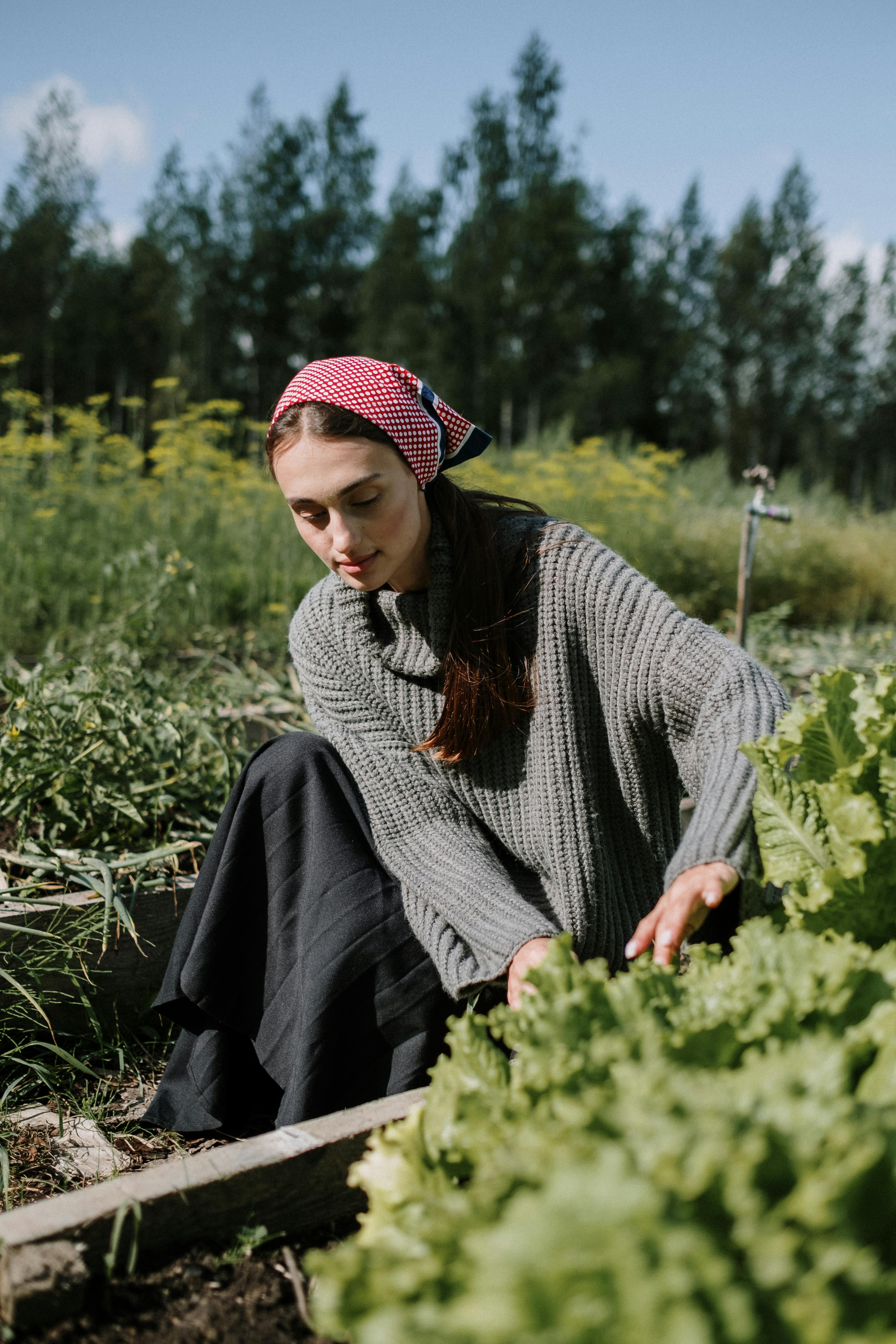 时尚的女人在夏季乡村环境中园艺，充满活力的绿色植物