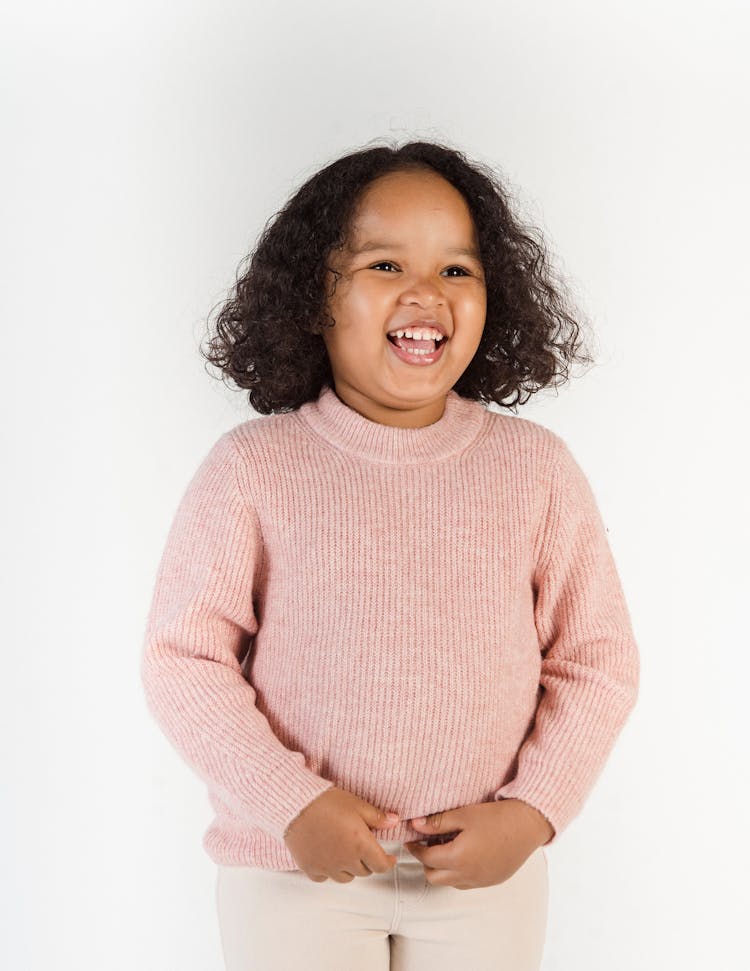 Joyful Black Girl Laughing Against White Wall