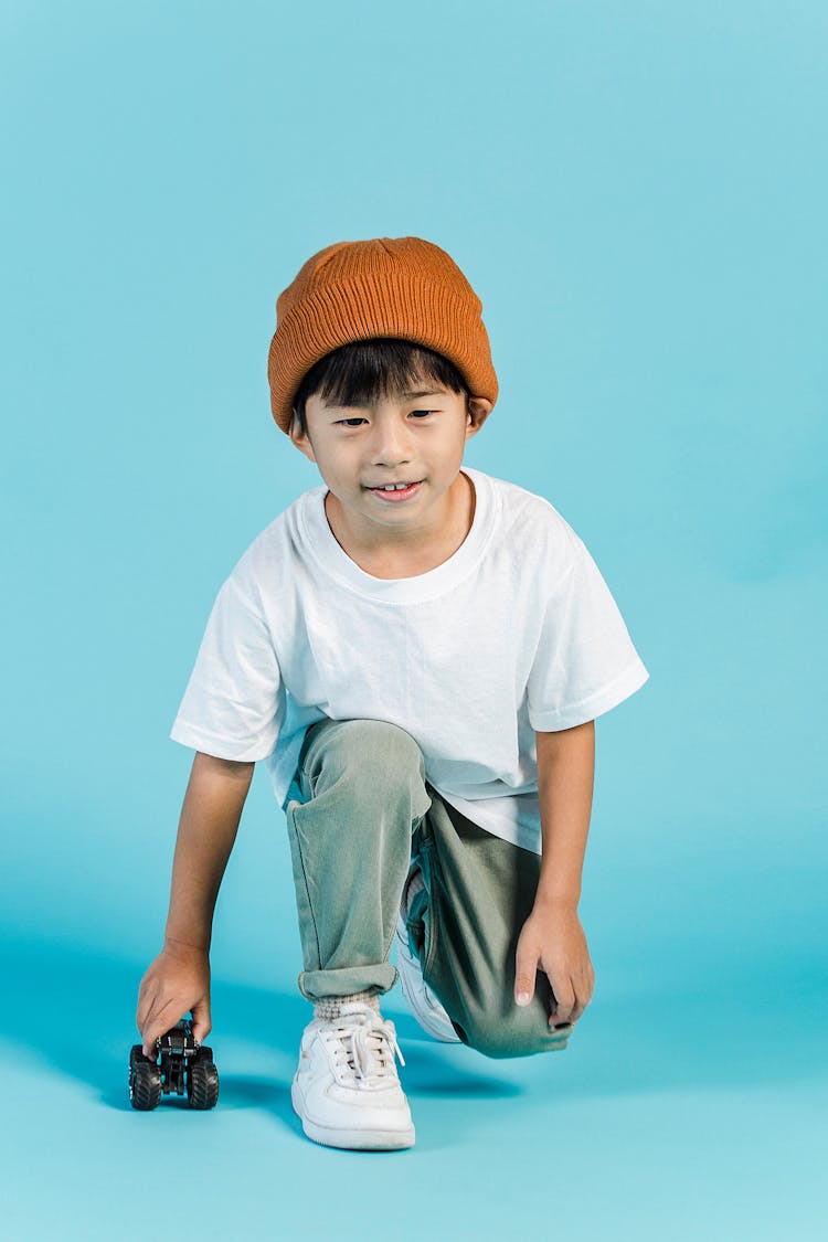 Content Asian Boy Playing With Toy Car In Studio