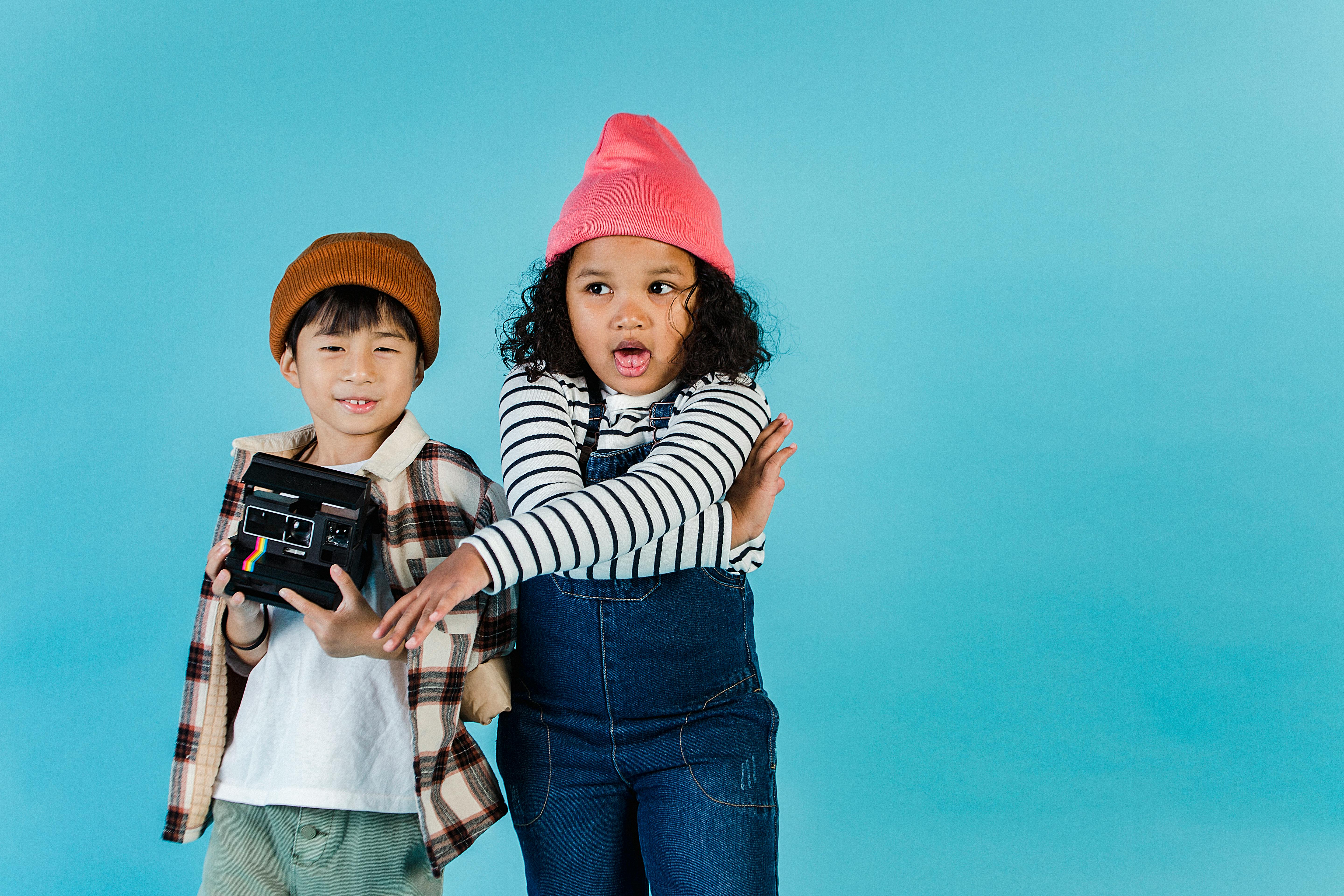 little multiethnic friends with retro photo camera standing together