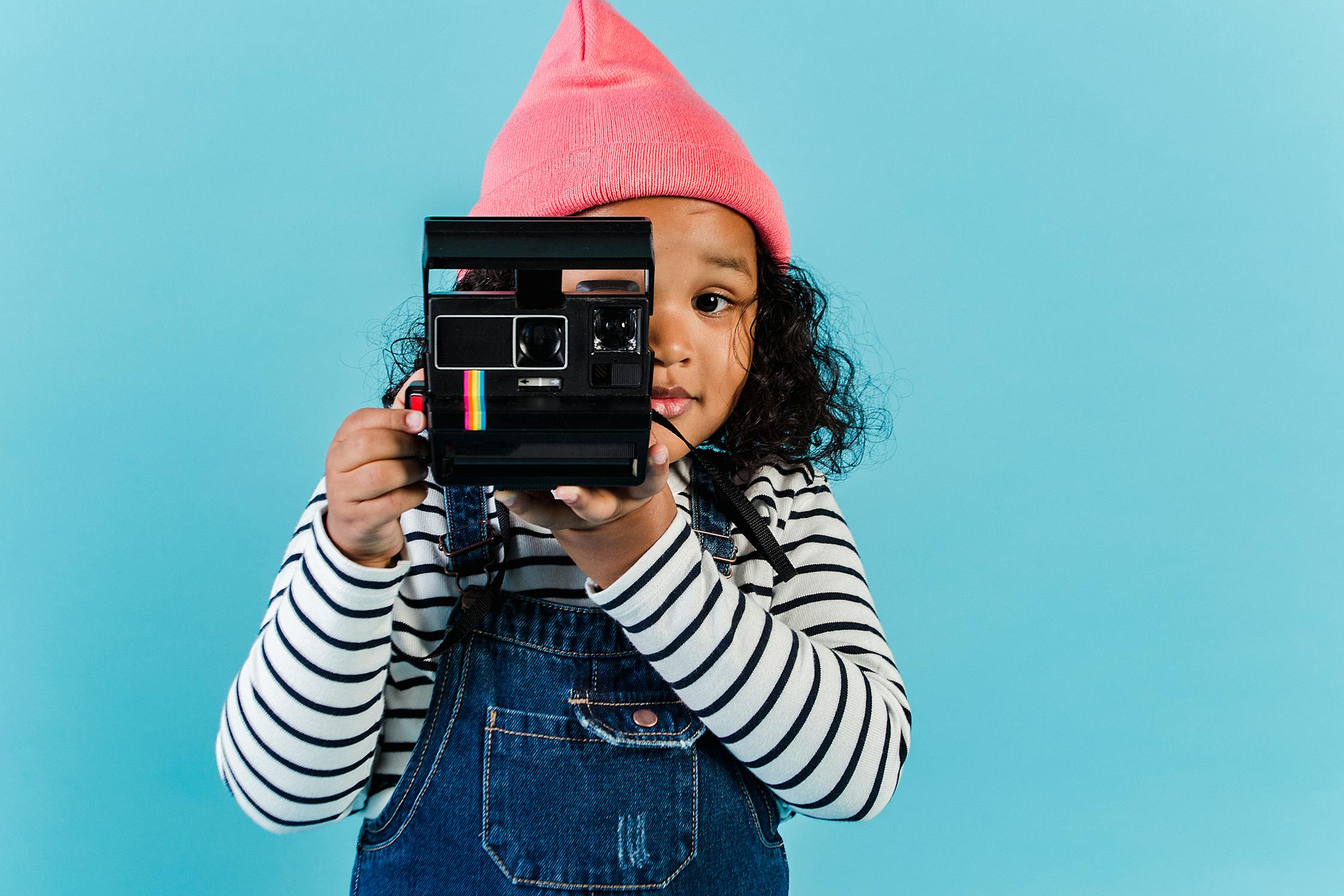 Photo by Amina Filkins from Pexels: https://www.pexels.com/photo/sweet-black-girl-taking-pictures-on-film-camera-5561461/