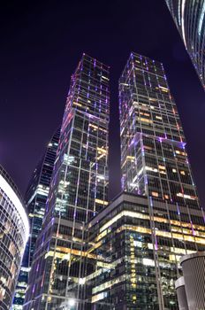 热闹城市中闪亮的摩天大楼，其夜间景观令人惊叹，展现了现代建筑的魅力