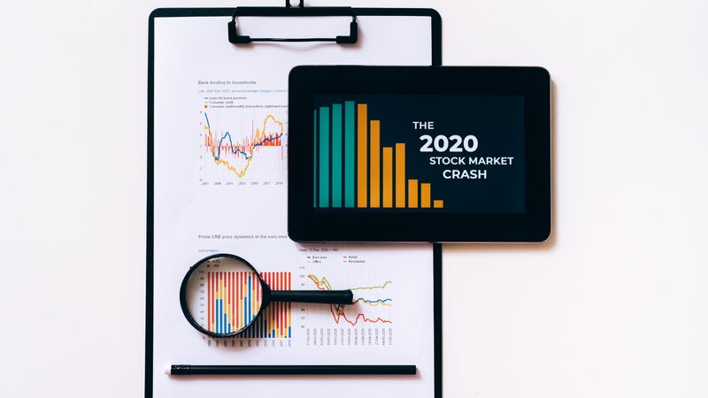 Tablet and clipboard with charts illustrating the 2020 stock market crash.