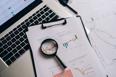 Printed report with charts under a magnifier — photo by Leeloo The First on Pexels