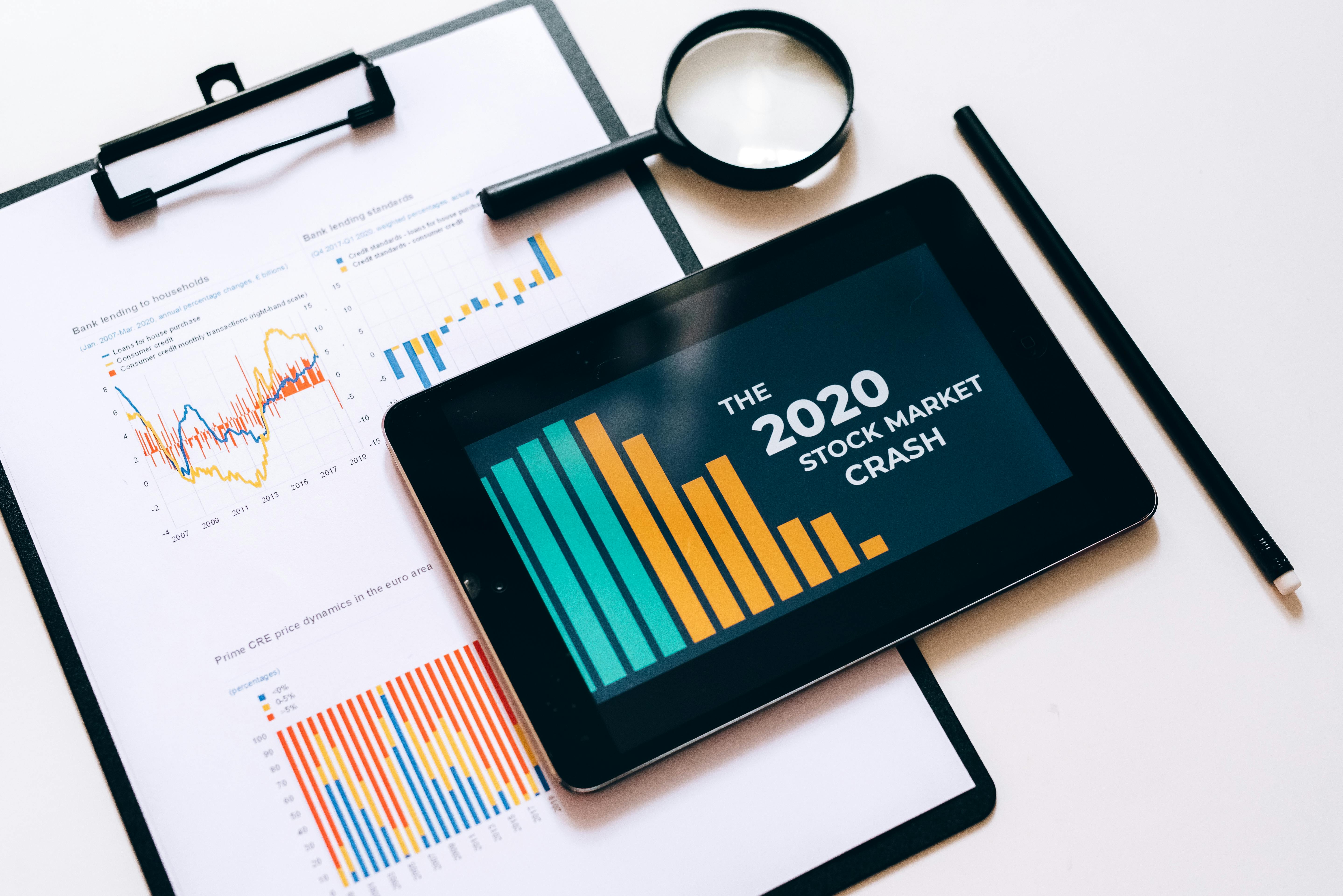 clipboard with statistical data and digital tablet with stock market display on screen