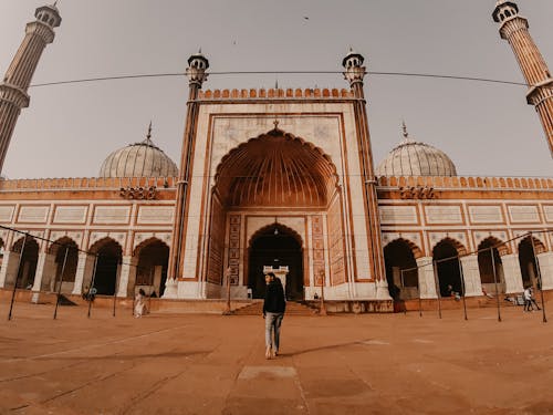 Free Man in Black Jacket Standing Near a Mosque Stock Photo