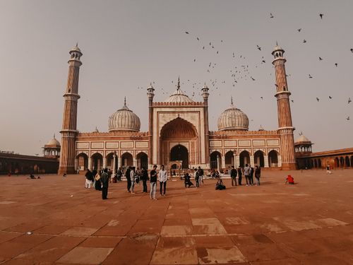 Free Iconic Jama Masjid in Delhi, India, with tourists and birds flying overhead. Stock Photo