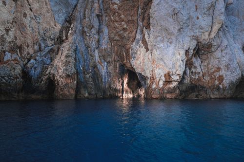 Free Breathtaking view of rocky cliff with rough surface in calm rippling sea water Stock Photo