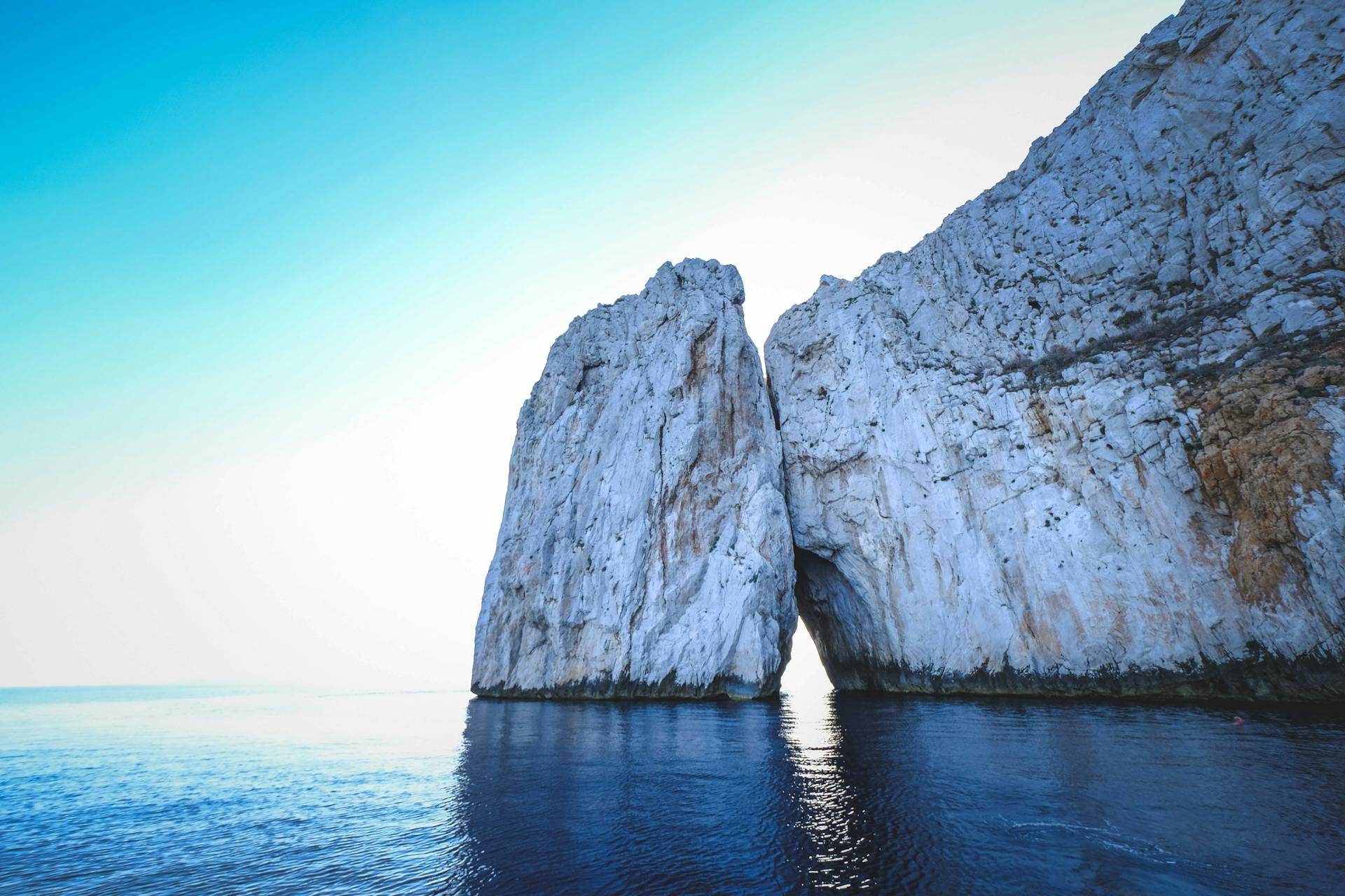 Rocky formations in sea under sky