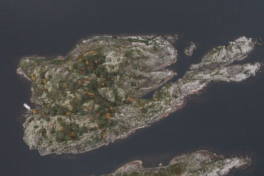 从空中俯瞰，卡累利阿的岩石岛被宁静的水域和秋叶环绕，景色壮丽