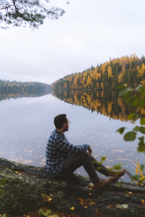 Free A Man Sitting Beside the Lake Stock Photo