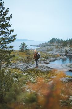一位穿着户外服装的徒步旅行者，正静静欣赏着湖畔优美的风景