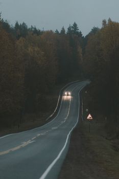 黄昏时分，汽车行驶在蜿蜒的道路上，穿过秋天的乡村