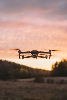 A drone captures a beautiful sunset with a scenic landscape background.