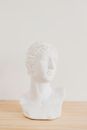 White Ceramic Angel Figurine on Brown Wooden Table