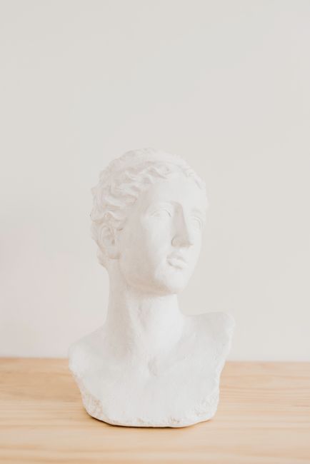 White marble bust sculpture on wooden table offering artistic elegance and minimalistic decor.
