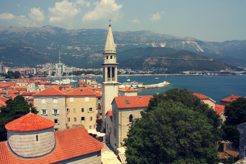 Free Panoramic view of Budva's historic old town with the Adriatic Sea and mountains in the background. Stock Photo