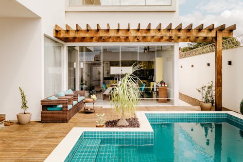 Modern lounge zone with swimming pool on terrace of modern villa in sunny day