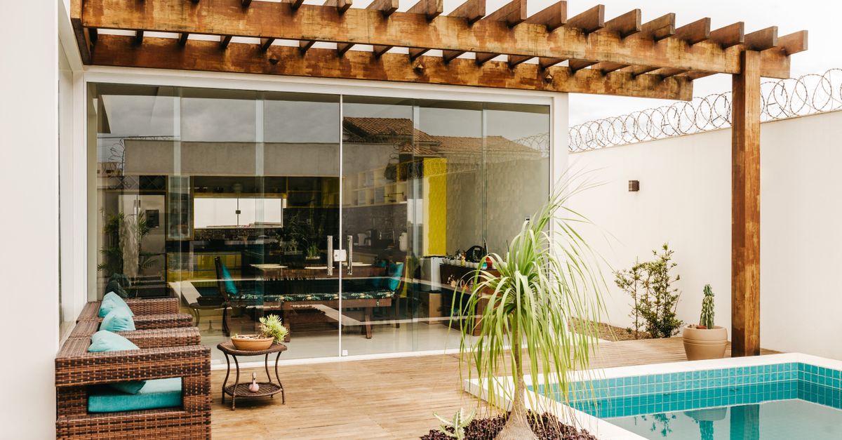 Cozy interior of lounge terrace with swimming pool in modern villa in daytime