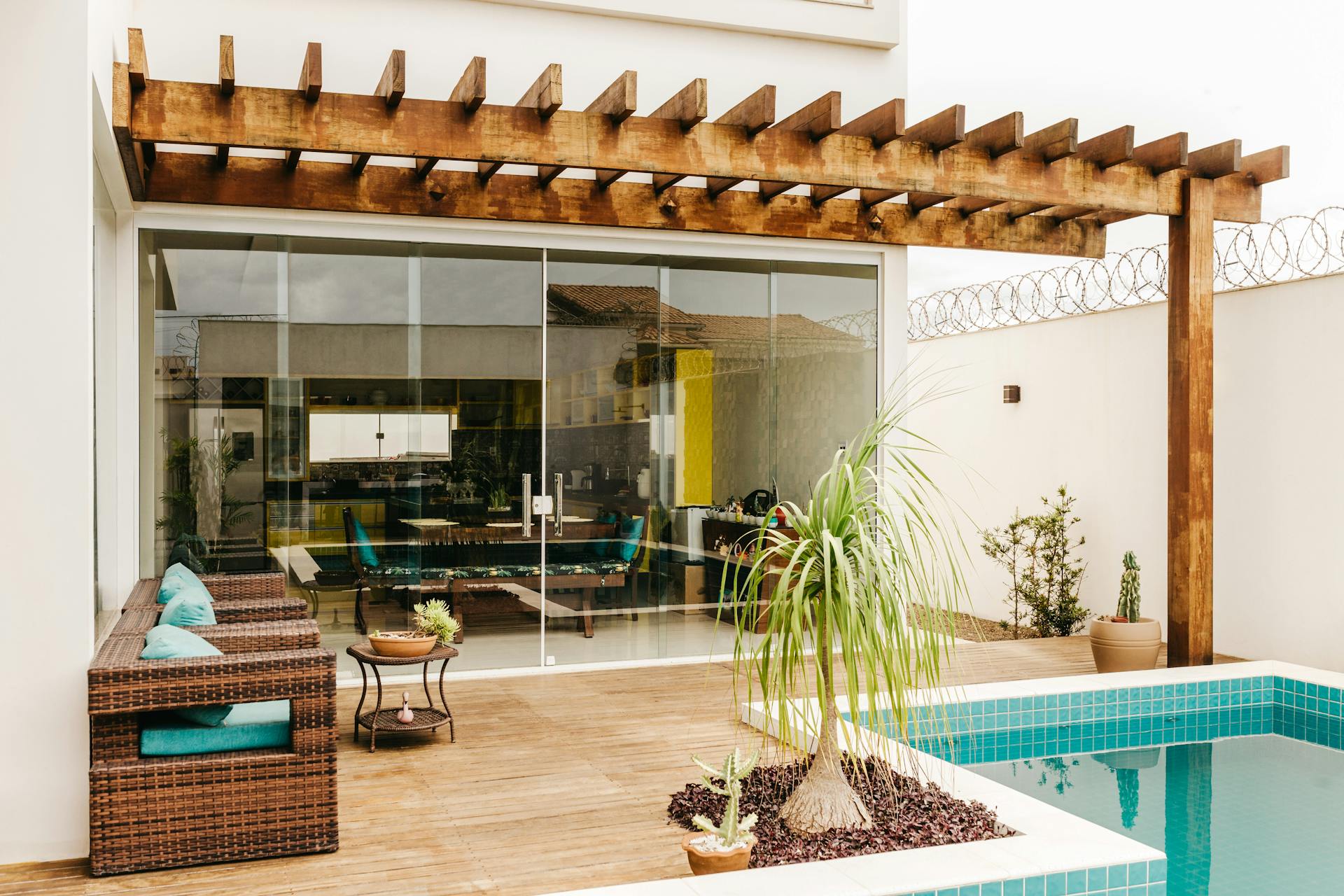 Stylish outdoor patio with wooden pergola and poolside lounge chairs for a relaxing experience.