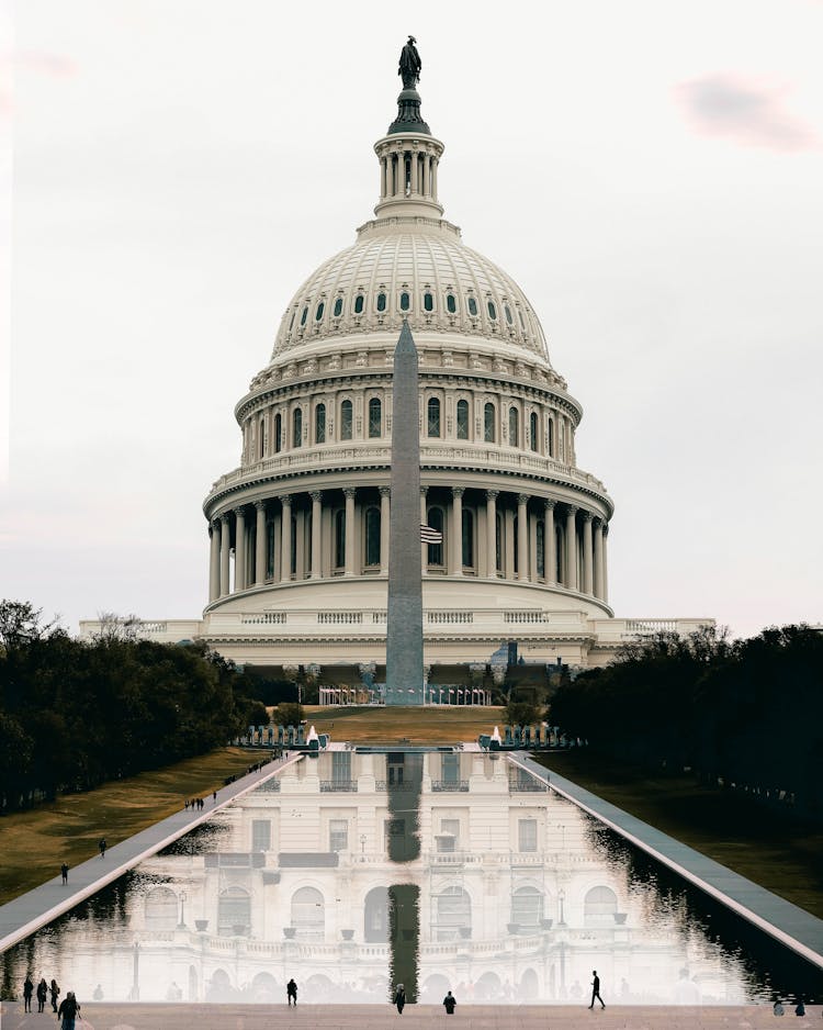 Washington State Capitol Facade Reflecting In Pond Under White Sky