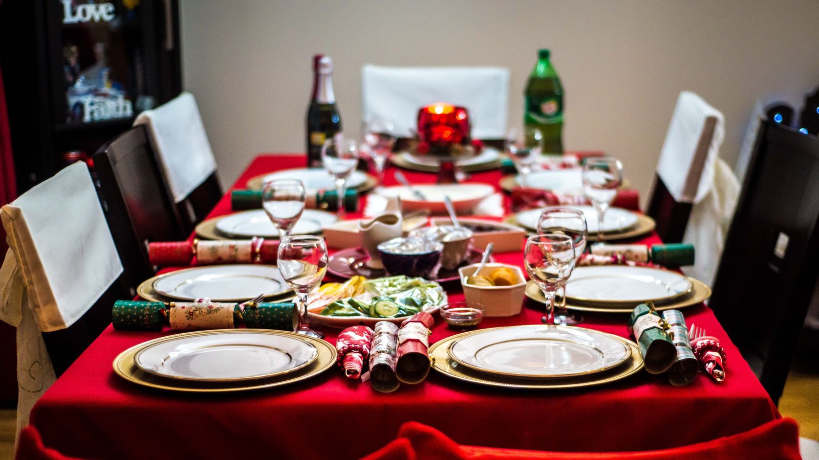 Festively decorated dining table with elegant place settings and holiday crackers - diy christmas centerpiece ideas