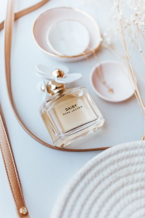 Free Stylish flat lay of a Daisy perfume bottle with chic accessories. Stock Photo