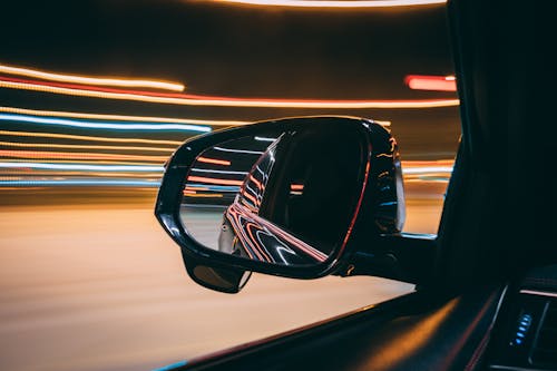 Black Car Side Mirror Showing Car at Night