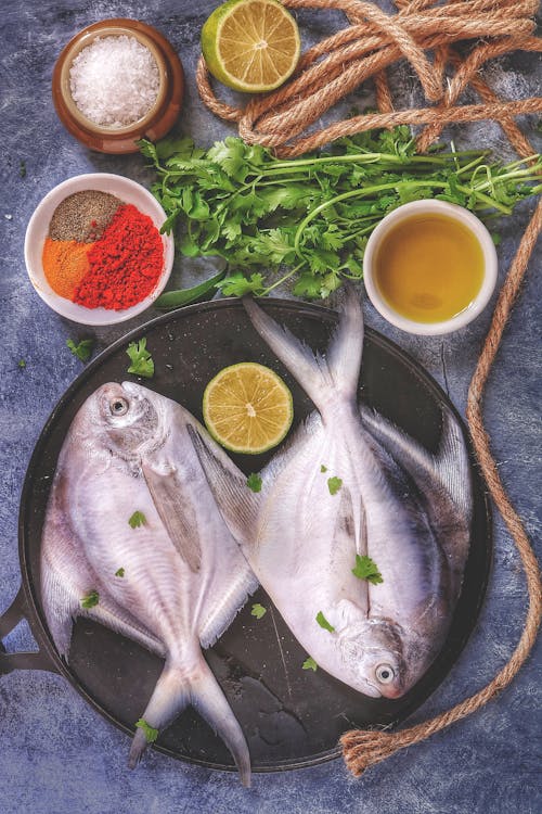 Two Whole Raw Fish on a Fry Pan with Slice Lemon