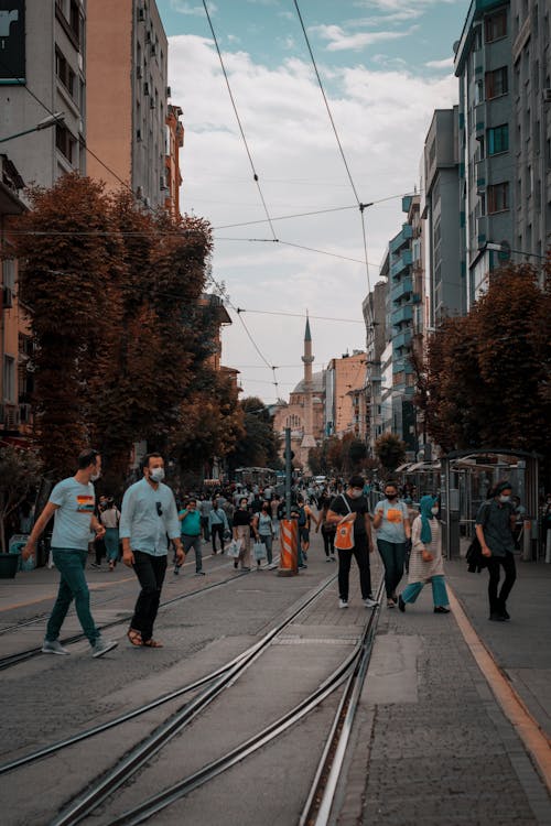People Crossing Street with Tramways in a City