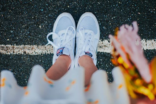 Free Woman in sneakers and pom pom on asphalt ground Stock Photo