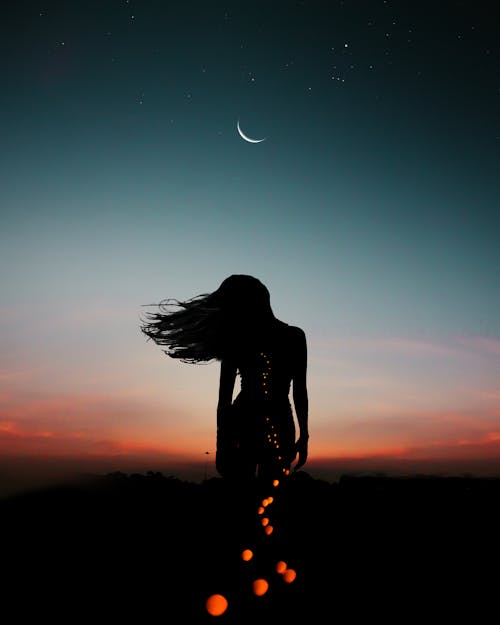 Silhouette of Person under Crescent Moon 