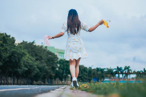 Free Low angle back view full body of anonymous female with pom poms walking on tiptoes near running track Stock Photo