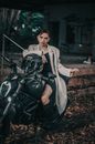 Stylish woman on motorcycle near aged building