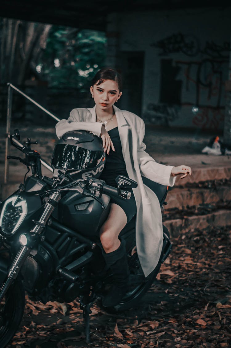 Stylish Woman On Motorcycle Near Aged Building