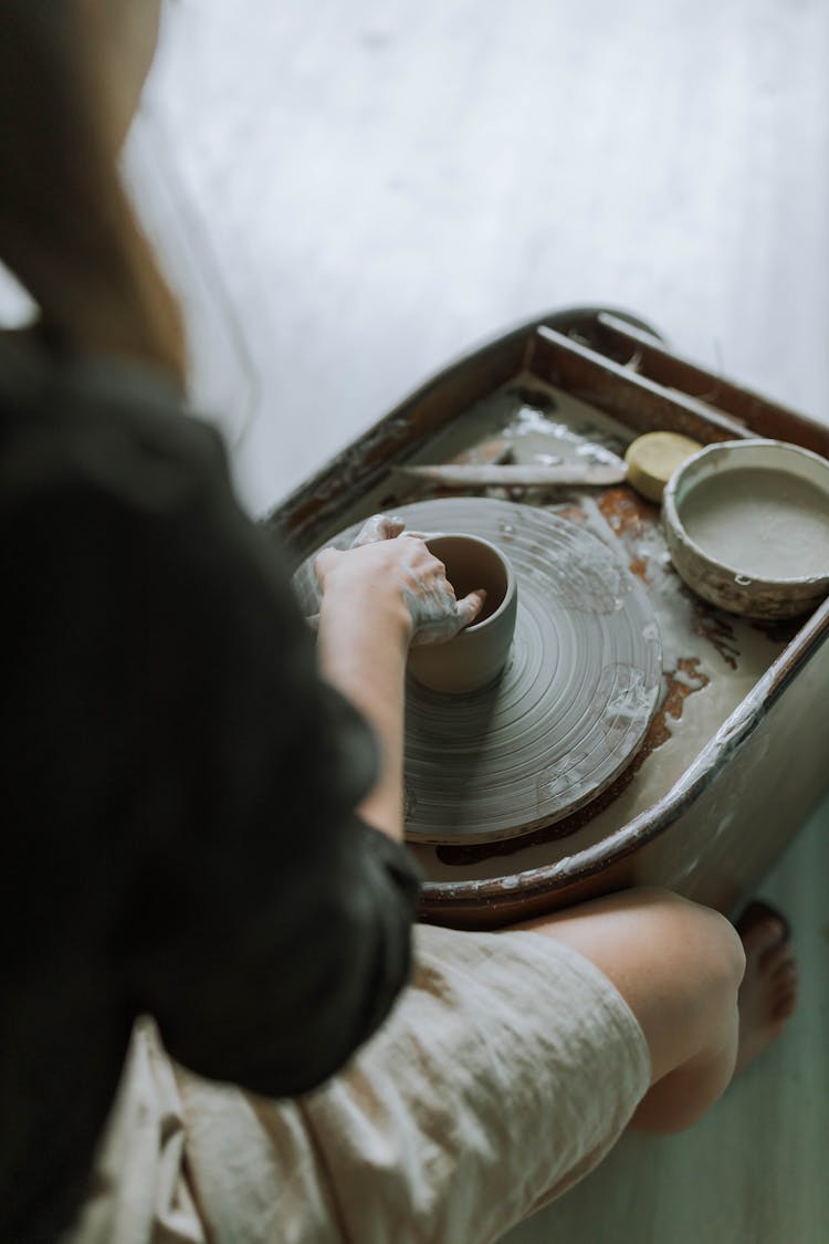 Woman Shaping A Clay On A Pottery Wheel