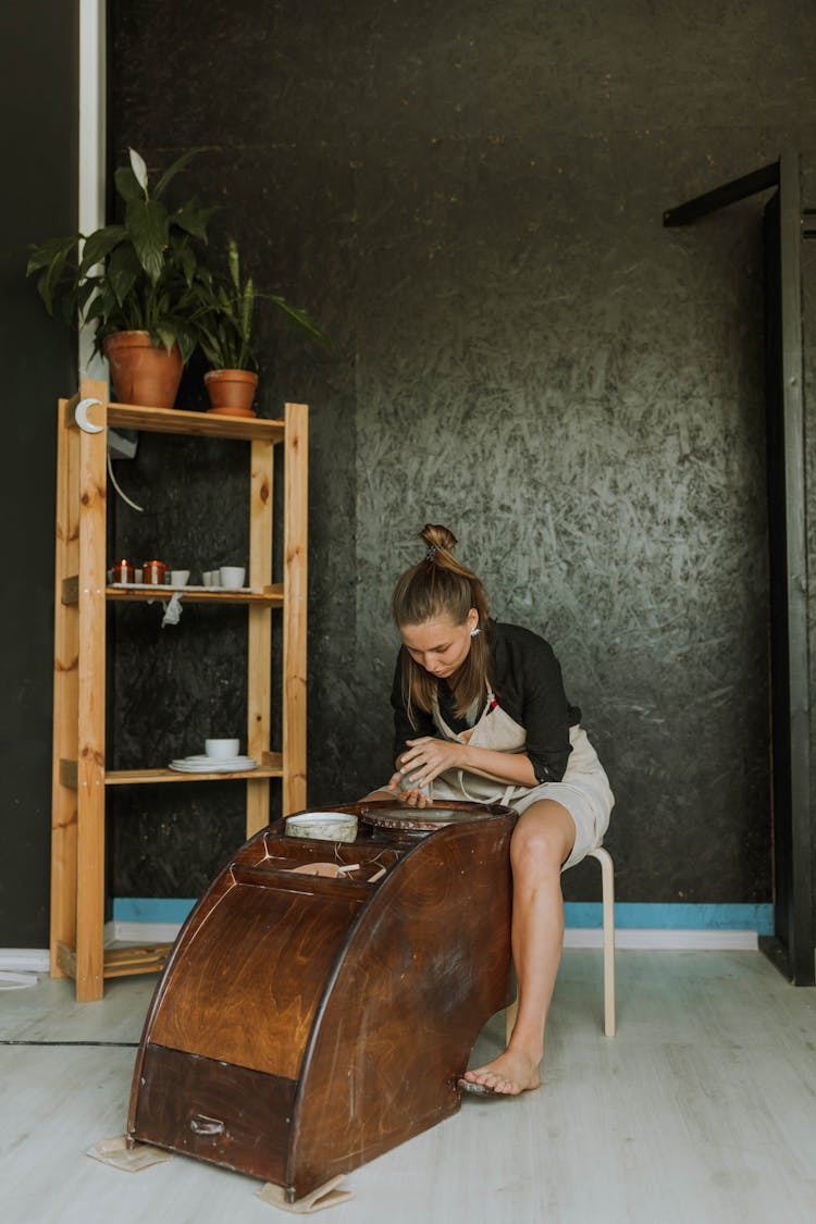 Pretty Woman Sitting Beside A Pottery Wheel