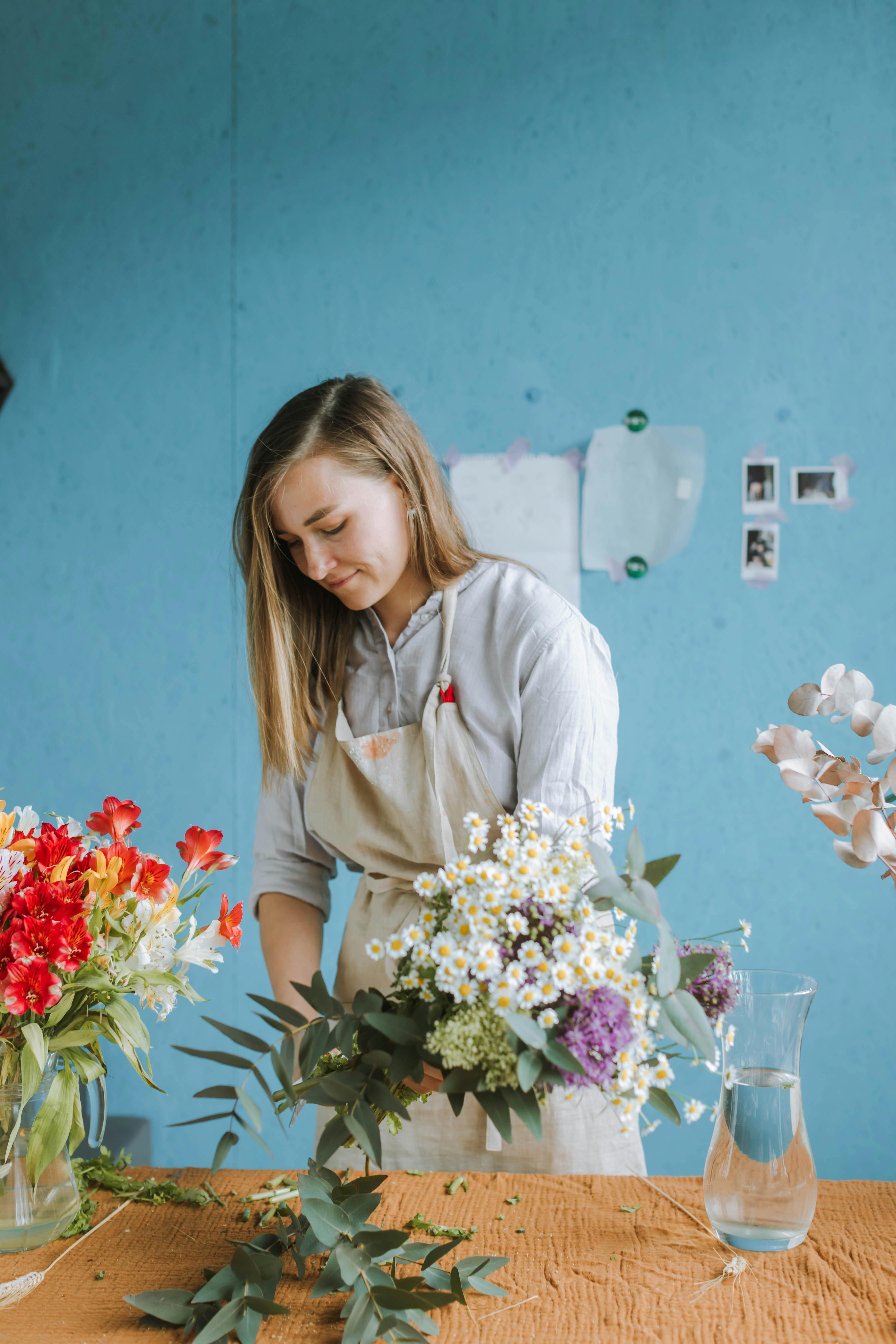 woman cutting stems of flowers